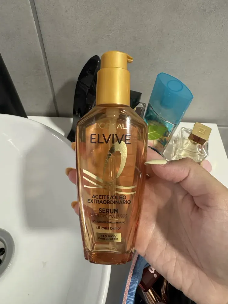 Foto de un sérum hecha con el móvil, en la mano y junto a un lavabo
