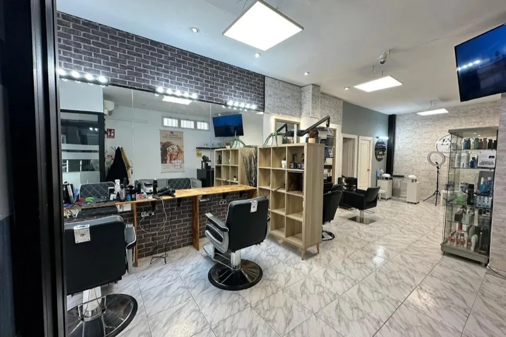 Barbería real antes: televisor, cables y productos por todas partes